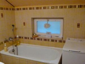 a bath tub in a bathroom with a window at Agroturystyka u Psotki in Kużmina