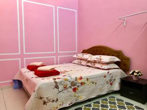 a bedroom with a bed with pink walls at D'Q Putra Homestay Melaka Unit MIQA in Melaka