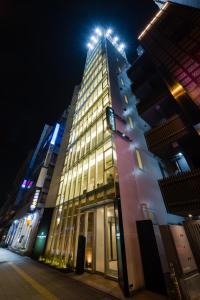 un edificio alto con luces en la parte superior por la noche en Tosei Hotel Cocone Ueno, en Tokio