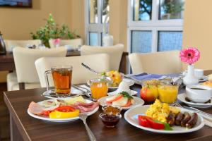 una mesa cubierta con platos de comida y bebida para el desayuno en INVITE Hotel Nürnberg City, en Núremberg