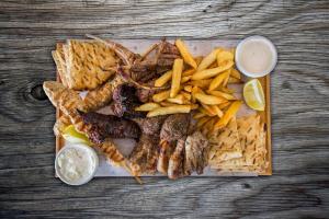 a plate of food with meat and french fries at Island Boutique Hotel in Larnaca