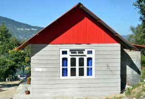 uma pequena casa com um telhado vermelho e uma janela em Vamoose Orange Valley Sittong em Karsiyang