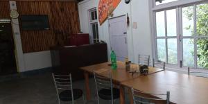 a table and chairs in a room with a large window at Orange Orchard in Karsiyang
