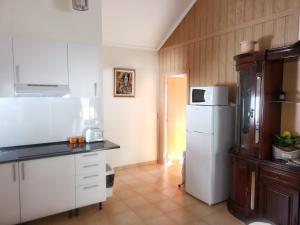 a kitchen with white cabinets and a white refrigerator at Costa Residence Funchal View in Funchal