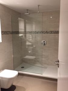 uma casa de banho com uma cabina de duche em vidro e um WC. em The Angel Hotel Wetherspoon em Whitby