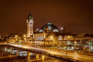 Un gran edificio con una torre de reloj por la noche. en Kyriad Limoges Centre Gare - Atrium, en Limoges