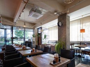 藤枝市にある藤枝パークインホテルの木製のテーブルと椅子、時計が備わるレストラン