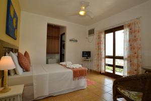 a bedroom with a bed and a large window at Pousada Fruto do Mar in Ilhabela