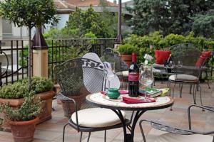 eine Terrasse mit Stühlen und einem Tisch mit einer Flasche Wein in der Unterkunft Hotel Villa Irma in Rimini