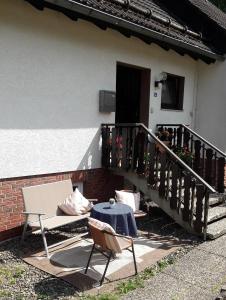 eine Terrasse mit einem Tisch, Stühlen und einer Treppe in der Unterkunft Ferienwohnung Bodehexe 2 in Braunlage