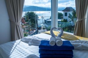 a bedroom with a bed with towels and a window at Celebrity Ocean View Villa Samui in Bang Rak Beach