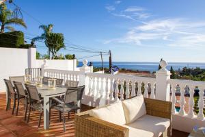 une terrasse avec une table et des chaises et l'océan dans l'établissement Villa Diann, à Benalmádena