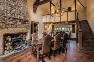 uma sala de jantar com lareira, mesa e cadeiras em The Old Hall Inn em Chinley