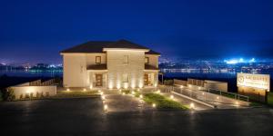 a building with lights in front of the water at night at La Suite Boutique Hotel & Spa in Ioannina