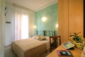 Schlafzimmer mit einem Bett und einem Schreibtisch mit einem Tisch in der Unterkunft Hotel Villa Irma in Rimini