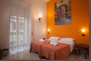 two beds in a room with orange walls at Anna's Family in Naples