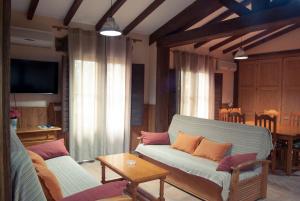 - un salon avec un canapé et une table dans l'établissement Apartamentos El Calambuco, à Villanueva de la Vera
