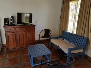 sala de estar con banco azul y TV en Rancho Aparte en Ituzaingó