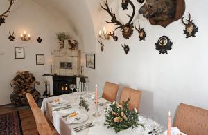 uma sala de jantar com uma mesa com flores e velas em Schlosshotel Zamek Zdikov em Zdíkov