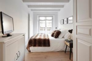 Naut AranにあるVal de Ruda Luxe 61 by FeelFree Rentalsの白いベッドルーム(ベッド1台、薄型テレビ付)