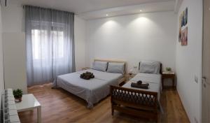 帕多瓦的住宿－CASAMINA，一间卧室设有两张床、一张长凳和一个窗户。