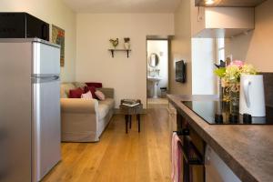 a kitchen and a living room with a couch at Les Hauts de Condom Appartements Climatises in Condom +6 photos