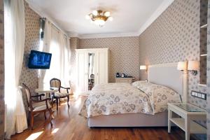 1 dormitorio con 1 cama, mesa y sillas en Spa Hotel Schlosspark, en Karlovy Vary