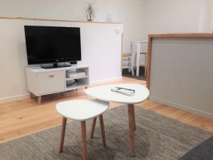 a living room with a table and a tv at Le T2 moderne des Palmiers au coeur de Moissac in Moissac