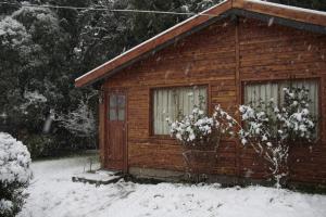 Cabaña de madera pequeña con nieve en el suelo en La Casita de Melipal en San Carlos de Bariloche