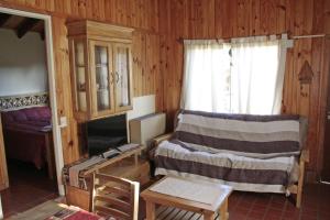 una habitación con una cama y una mesa y una ventana en La Casita de Melipal, en San Carlos de Bariloche