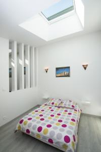 um quarto com uma cama com lençóis de bolinhas em Gîte de vac's et d'affaires à Deville Secteur Monthermé - Ardennes em Deville