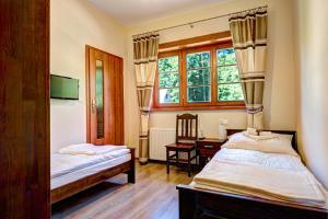 a room with two beds and a desk and a window at Noclegi Styrnol & SPA in Zawoja