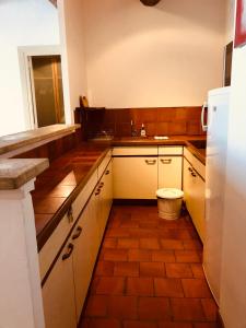 a kitchen with white cabinets and a brown tile floor at Escapade Vieux-Port in Marseille