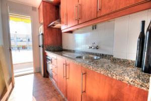a kitchen with wooden cabinets and a sink at Paradise Beach in Caleta De Velez