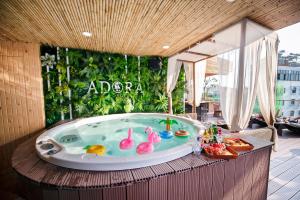 a jacuzzi tub on a balcony with a garden at Adora Hotel in Ho Chi Minh City