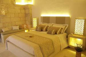 a bedroom with a large bed and a couch at Corte Dei Granai in Maglie