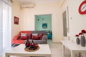 a living room with a red couch and a table at Sissy’s House in Preveza
