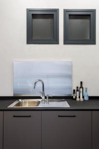 encimera de cocina con fregadero y 2 ventanas en Oak & Sandstone Studio - Space Maison Apartments, en Sevilla