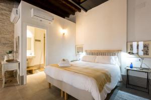 Un dormitorio con una gran cama blanca en una habitación. en Oak & Sandstone Studio - Space Maison Apartments, en Sevilla