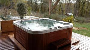 a hot tub sitting on top of a wooden deck at Gîte Chez EVA in Le Buisson de Cadouin +2 photos