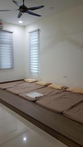 uma cama grande num quarto com uma ventoinha de tecto em Malacca Homestay - 2 Storey Semi-D em Malaca