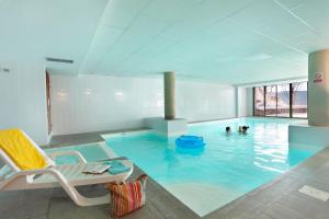 a large pool with two people in the water at Résidence Néméa Les Chalets Du Belvédère in Font-Romeu