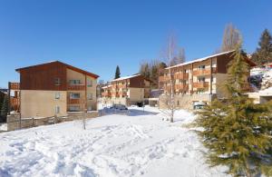 a snow covered parking lot in front of a building at Résidence Néméa Les Chalets Du Belvédère in Font-Romeu