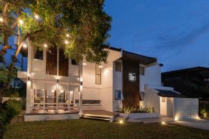 a white house with lights on it at night at The Mellow Pillow Hotel @ Chiang Mai Gate in Chiang Mai
