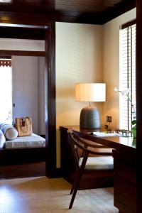 a bedroom with a desk and a bed with a lamp at Gaya Island Resort - Small Luxury Hotels of the World in Gaya Island