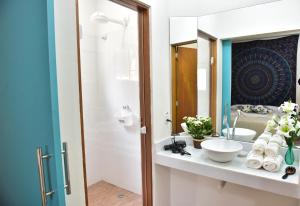 a bathroom with a sink and a mirror at Guaiamu Suítes Ilhabela in Ilhabela