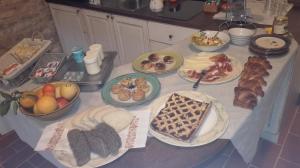 uma mesa com muitos pratos de comida em Il Gelso Room&breakfast em Pennabilli