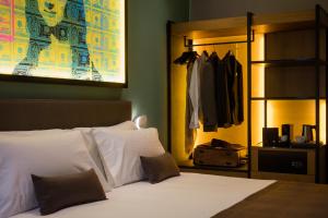 フィレンツェにあるThe Frame Hotelのベッドルーム(白いベッド1台、クローゼット付)