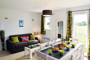 a living room with a table and a couch at Résidence Néméa Les Grands Rochers in Les Sables-d'Olonne