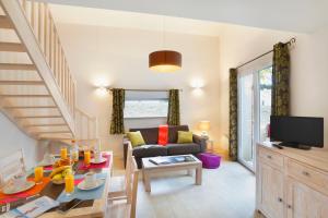 un soggiorno con tavolo e un soggiorno con divano. di Résidence Goélia Les Grands Rochers a Les Sables-dʼOlonne